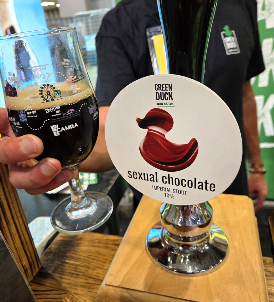 A beer glass containing Green Duck Sexual Chocolate 10% imperial stout alongside its pump clip